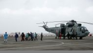 People who were stranded at sea due to Cyclone Tauktae exit an Indian Navy Sea King Mk.42C helicopter, after they were rescued by the Indian Navy, at INS Shikra, Colaba, Mumbai, India, May 18, 2021. REUTERS/Francis Mascarenhas
