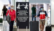FILE PHOTO: Passengers wearing protective face masks walk at Fiumicino Airport on the day EU governments agreed a 