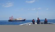 File photo: Philippine Coast Guard personnel survey several ships believed to be Chinese militia vessels in Sabina Shoal in the South China Sea, in a handout photo distributed by the Philippine Coast Guard on May 5 and taken according to source on April 2