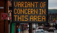 FILE PHOTO: A woman walks past an information sign amid the outbreak of the coronavirus disease (COVID-19) in Bolton, Britain, May 17, 2021. REUTERS/Phil Noble/File Photo
 