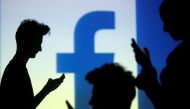 FILE PHOTO: People are silhouetted as they pose with mobile devices in front of a screen projected with a Facebook logo, in this picture illustration taken in Zenica October 29, 2014. REUTERS/Dado Ruvic/File Photo
