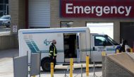 FILE PHOTO: A health care worker in a surgical mask helps unload a stretcher service vehicle at St. Boniface Hospital in Winnipeg, Manitoba, Canada, November 1, 2020. REUTERS/Shannon VanRaes/File Photo
