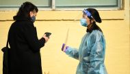 A healthcare worker speaks with a member of the public waiting in line to get tested for the coronavirus disease outside a walk-in testing facility in Melbourne, Australia, May 26, 2021. AAP Image/James Ross via Reuters