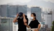 A couple wearing masks to avoid contracting the coronavirus disease (COVID-19) take a walk at a park in Seoul, South Korea, May 26, 2021. REUTERS/Kim Hong-Ji
