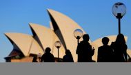 FILE PHOTO: People are silhouetted against the SYDNEY Opera House at sunset in Australia, November 2, 2016. REUTERS/Steven Saphore/File Photo
