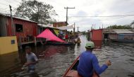 A man paddles his canoe through the streets during flooding by the overflowing Negro river at Cacau Pirera neighborhood in Iranduba, Amazonas state, Brazil, May 31, 2021. REUTERS/Bruno Kelly