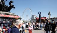 People wearing protective masks walk on Westminster Bridge, with the London Eye in the background, in London, Britain, June 1, 2021. REUTERS/John Sibley
