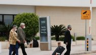 A taxi driver helps tourists with their luggage outside the arrivals terminal amid the coronavirus disease pandemic, as Malta officially restarted its tourism season. Reuters/Darrin Zammit Lupi
