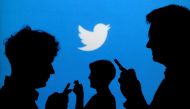 FILE PHOTO: People holding mobile phones are silhouetted against a backdrop projected with the Twitter logo in this illustration picture taken September 27, 2013. REUTERS/Kacper Pempel/Illustration/File Photo