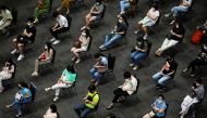 People wait to receive the first dose of the AstraZeneca COVID-19 vaccine against the coronavirus disease (COVID-19) as Thailand start a mass inoculation at a gymnasium inside the Siam paragon Shopping center, Bangkok, Thailand June 7, 2021. REUTERS/Soe Z