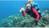 Resort owner and dive instructor Carmela Sevilla shows a plastic trash she recovered underwater during a scuba diving activity in Bauan, Batangas, Philippines, June 6, 2021. Picture taken June 6, 2021. REUTERS/Peter Blaza