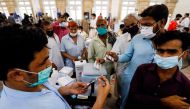 Residents with their registration cards gather at a counter to receive a dose of coronavirus disease (COVID-19) vaccine at a vaccination center in Karachi, Pakistan June 9, 2021. REUTERS/Akhtar Soomro
