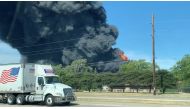 A truck passes a chemical fire at the Chemtool plant, which manufactures oil-based lubricants and is situated about 985ft (300m) from the Rock River, in Rockton, Illinois, U.S. June 14, 2021, in this social media video still image taken through a window. 