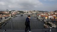 FILE PHOTO: A man walks on Dom Luis I Bridge in Porto ahead of the Champions League Final, May 28, 2021. REUTERS/Pedro Nunes