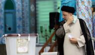 Presidential candidate Ebrahim Raisi holds his mask as he arrives to cast his vote during presidential elections at a polling station in Tehran, Iran June 18, 2021.