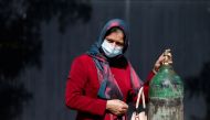 A woman waits outside a factory to get her oxygen cylinder refilled, amidst the spread of the coronavirus disease (COVID-19) in Kabul, Afghanistan on June 15, 2021. (REUTERS)
