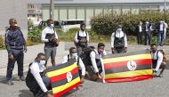 Members of Uganda's Olympic team pose for a photograph upon their arrival at their pre-Olympics camp host town Izumisano, after a member of their team has tested positive fo the coronavirus disease (COVID-19) and was barred entry into Japan, in Izumisano,
