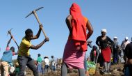 A person uses a pickaxe to dig as fortune seekers flock to the village after pictures and videos were shared on social media showing people celebrating after finding what they believe to be diamonds, in the village of KwaHlathi, outside Ladysmith, in KwaZ