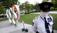 Security personnel stand guard near the Olympic rings monument outside the Japanese Olympic Committee headquarters. REUTERS/Issei Kato/File Photo