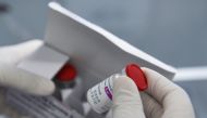 A health worker holds a vial of the vaccine as Vietnam starts its official rollout of AstraZeneca's coronavirus disease (COVID-19) vaccine for health workers, at Hai Duong Hospital for Tropical Diseases, Hai Duong province, Vietnam, March 8, 2021. REUTERS
