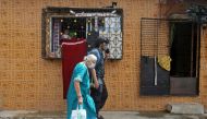 Madhura Samel, 81, walks with Om Rajesh Yadav, a volunteer from Robin Hood Army, a volunteer-based organisation, to board a taxi to reach to a coronavirus disease (COVID-19) vaccination centre in Mumbai, India, June 21, 2021. Picture taken on June 21, 202