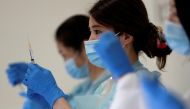 A health worker fills a syringe with a dose of the Pfizer-BioNTech coronavirus disease (COVID-19) vaccine at the Noevir Stadium Kobe, the home venue of Japanese professional soccer club Vissel Kobe and currently acting as a large-scale COVID-19 vaccinatio