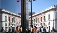 People wearing protective face masks walk at Puerta del Sol square as the country will lift a blanket obligation to wear masks outdoors from June 26, in Madrid, Spain, June 24, 2021. REUTERS/Sergio Perez 