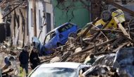 People walk among debris of damaged houses and cars in the aftermath of a rare tornado that struck and destroyed parts of some towns, in Mikulcice village, Czech Republic, June 25, 2021. REUTERS/David W Cerny
