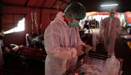 Healthcare workers prepare to assist COVID-19 patients at a temporary tent outside the emergency ward of a government hospital in Bekasi, on the outskirts of Jakarta, Indonesia, June 25, 2021. REUTERS/Willy Kurniawan
