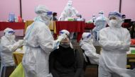 A medical worker collects a swab sample from a woman to be tested for the coronavirus disease (COVID-19) in Cyberjaya, Malaysia, June 2, 2021. REUTERS/Lim Huey Teng/File Photo
