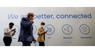 People walk past a banner, at the Mobile World Congress (MWC) in Barcelona, Spain, yesterday.