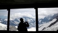 A tourist takes a picture from a window during an intermediate stop at Eismeer station on the way to Jungfraujoch, in Switzerland June 28, 2021. Picture taken June 28, 2021. REUTERS/Arnd Wiegmann
