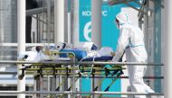 A medical specialist wearing protective gear transports a person on a stretcher at a hospital for patients infected with the coronavirus disease (COVID-19) on the outskirts of Moscow, Russia July 2, 2021. REUTERS/Tatyana Makeyeva