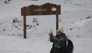 A tourist takes a photo at a mountain resort as Chile's health authority lifts closure restrictions at Farellones Park in Santiago, Chile, July 1, 2021. REUTERS/Pablo Sanhueza