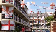 People walk through the Kirby Estate, which has been decorated with hundreds of England flags, in London, Britain, July 2, 2021. (Reuters/Henry Nicholls)