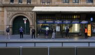 People wearing protective masks maintain social distance while waiting at a bus stop in the city centre during a lockdown to curb the spread of the coronavirus disease (COVID-19) in Sydney, Australia, July 5, 2021. REUTERS/Loren Elliott