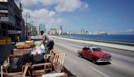 A man loads a truck with furniture to be relocated prior to the arrival of Storm Elsa, in Havana, Cuba, July 4, 2021. REUTERS/Alexandre Meneghini
