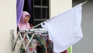 Halijah Naemat, 74, puts away a white flag after she received help from others at her home during an enhanced lockdown, amid the coronavirus disease (COVID-19) outbreak, in Petaling Jaya, Malaysia July 6, 2021. Picture taken July 6, 2021. REUTERS/Lim Huey