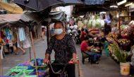 A vendor wearing a protective face mask, amid the spread of the coronavirus disease (COVID-19), cycles past a flower market in Manila, Philippines, March 12, 2021. REUTERS/Eloisa Lopez

