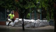 A worker places sandbags to stop floods as Tropical Storm Elsa passes through Hoboken, New Jersey, U.S., July 9, 2021. REUTERS/Eduardo Munoz
