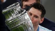 July 10, 2021 Argentina's Lionel Messi celebrates winning the Copa America as he kisses the trophy REUTERS/Ricardo Moraes