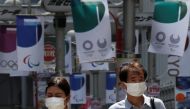 Pedestrians wear protective masks during the ongoing coronavirus disease (COVID-19) pandemic, walk underneath Tokyo 2020 Olympic banners in Tokyo, Japan, July 12, 2021. REUTERS/Kim Kyung-Hoon