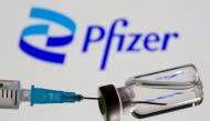 FILE PHOTO: Syringe and vial are seen in front of displayed new Pfizer logo in this illustration taken, June 24, 2021. REUTERS/Dado Ruvic/Illustration