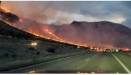 Flames are seen on side of highway after a bushfire broke out, near St. George, Arizona, U.S., July 12, 2021, in this still image obtained from a social media video. Twitter @WHILEINTEXAS/ via REUTERS