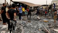 People gather as they inspect the damage at al-Hussain coronavirus hospital where a fire broke out, in Nassiriya, Iraq, July 13, 2021. REUTERS/Khalid al-Mousily
