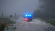 A vehicle travels on a flood-affected road after the Erft river swelled following heavy rainfalls in Erftstadt, near Cologne, Germany, July 15, 2021. REUTERS/Wolfgang Rattay