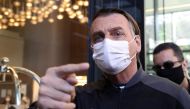 Brazil's President Jair Bolsonaro gestures, wearing a face mask, as he leaves Vila Nova Star Hospital, where he was treated due to obstructed intestine, in Sao Paulo, Brazil July 18, 2021. REUTERS/Amanda Perobelli
