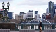 A lone woman, wearing a protective face mask, walks across an unusually quiet city centre bridge on the first day of a lockdown as the state of Victoria looks to curb the spread of a coronavirus disease (COVID-19) outbreak in Melbourne, Australia, July 16