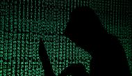 FILE PHOTO: A hooded man holds a laptop computer as cyber code is projected on him in this illustration picture taken on May 13, 2017.\. REUTERS/Kacper Pempel/Illustration/File Photo

