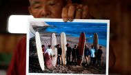 Japanese surf pioneer Teruo 'Ted' Adegawa (78) shows off his old photograph at his home in Isumi, southeast of Tokyo, Japan, June 30, 2021. (REUTERS/Androniki Christodoulou)